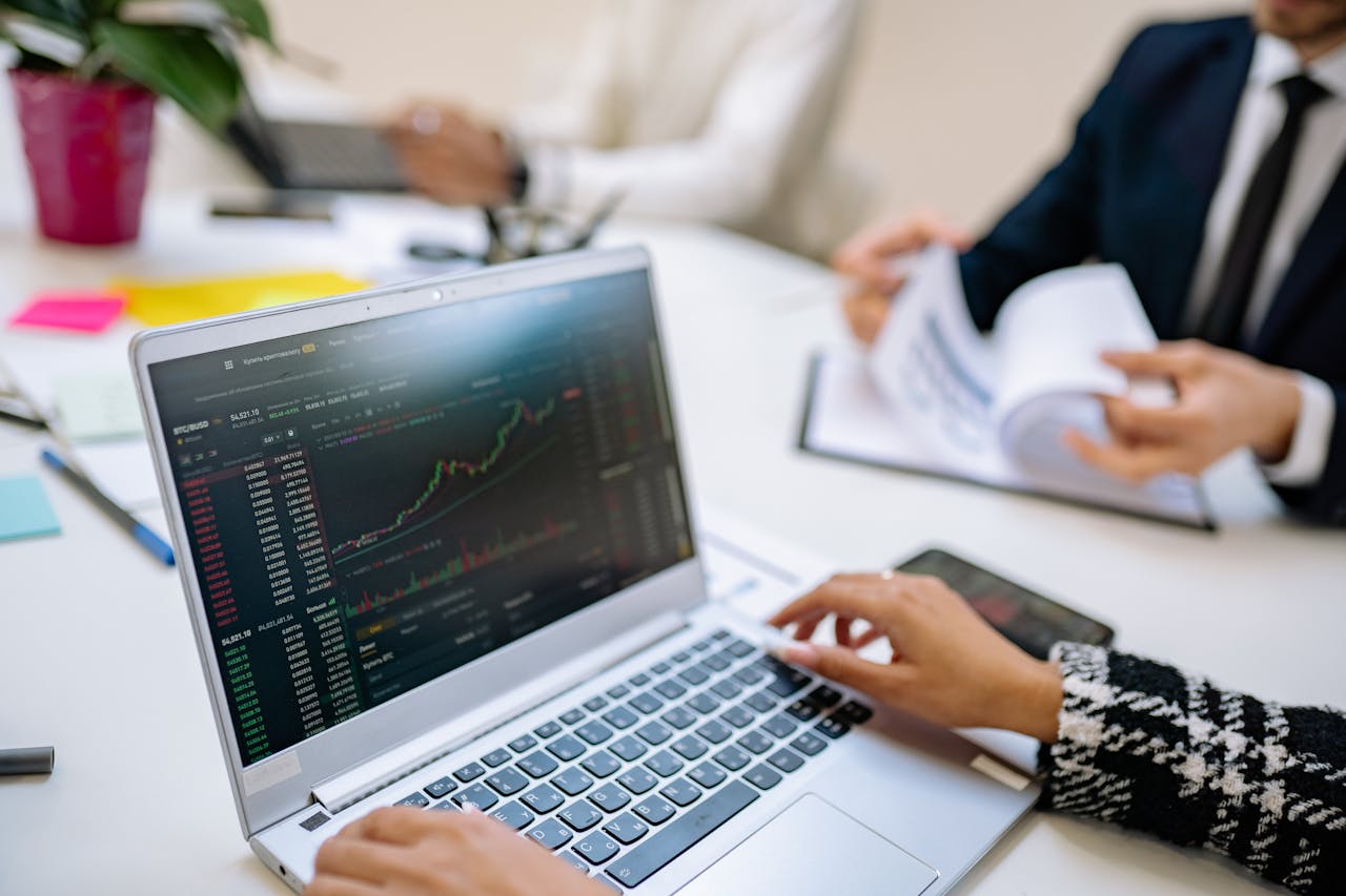 services-02 Business team analyzes cryptocurrency market trends using a laptop with graphs and data.
